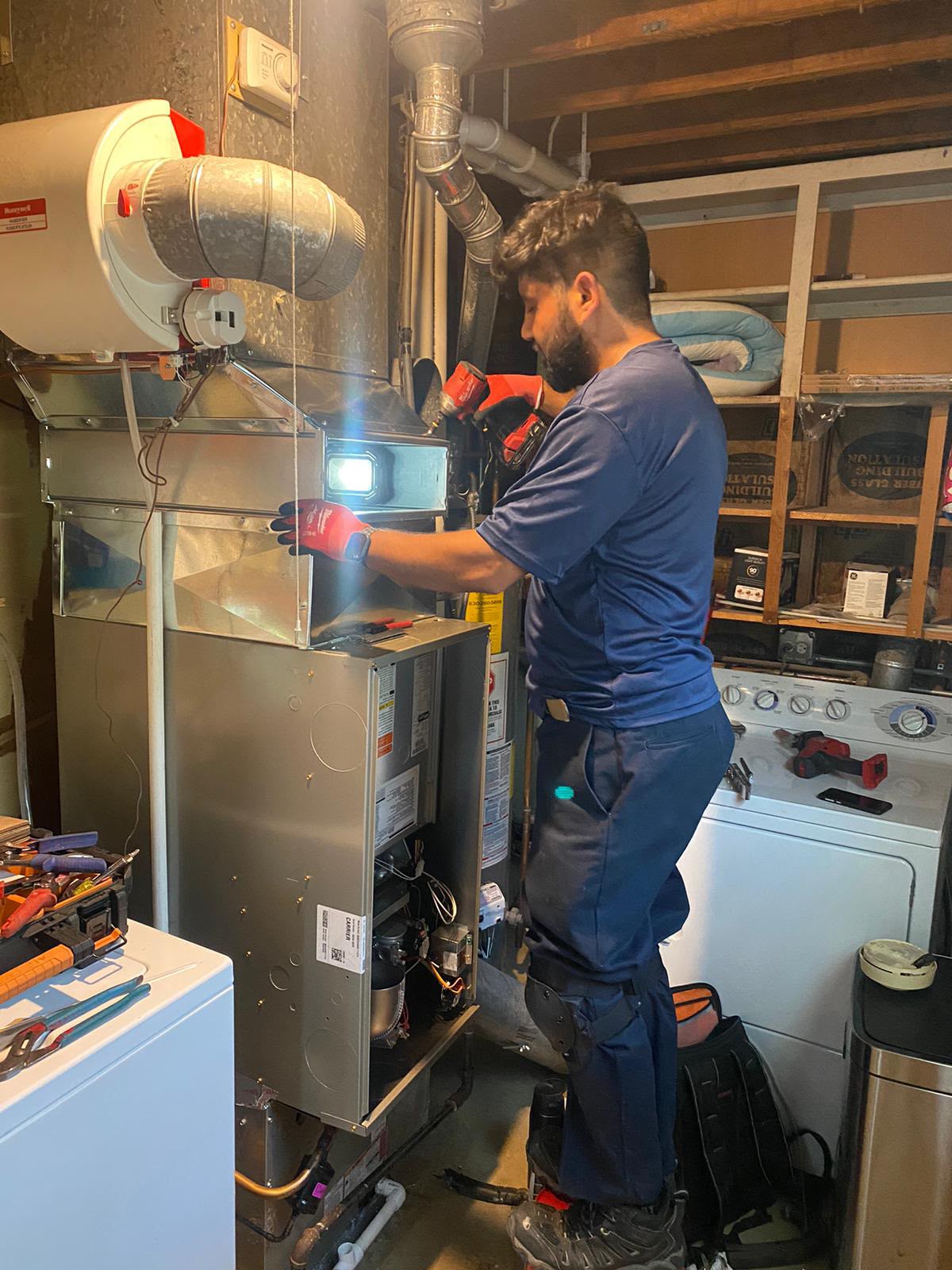 Ali HVAC technician working on furnace ductwork